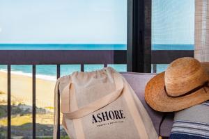 eine Person mit einem Hut auf einer Couch mit einer Tasche in der Unterkunft Ashore Resort & Beach Club in Ocean City