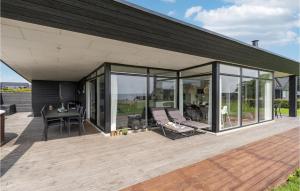 a house with glass doors and a wooden deck at Amazing Home In Haderslev With Kitchen in Kelstrup Strand