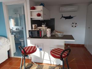 una cocina con 2 sillas rojas y una barra en Casetta Mami en Camogli