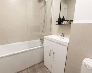 a bathroom with a sink and a tub and a toilet at Western House, Sleeps 5, Free parking, Longer stay savings in Reading