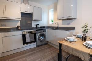 a kitchen with white cabinets and a table and a sink at Western House, Sleeps 5, Free parking, Longer stay savings in Reading