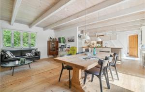 uma sala de jantar e sala de estar com uma mesa de madeira e cadeiras em Trojlhyttan em Bedegård