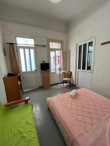 a bedroom with a bed and a chair and windows at Traditional Lemon House near to Pireaus Port in Piraeus