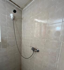 a shower with a hose in a tiled bathroom at Traditional Lemon House near to Pireaus Port in Piraeus
