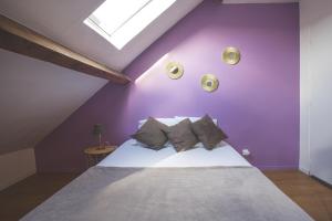 トゥールコワンにあるColocation de luxe à Tourcoing avec jardinの紫の壁のベッドルーム1室、ベッド1台(枕付)
