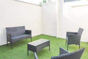three chairs and a table on a patio with grass at Colocation de luxe à Tourcoing avec jardin in Tourcoing