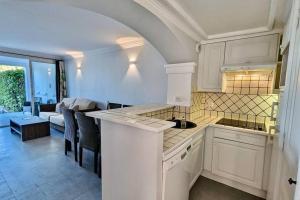 una cucina con mobili bianchi e un soggiorno di Les Restanques 3 chambres 3020 a Grimaud