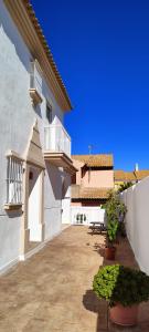 a courtyard of a white building with potted plants at La Tahona 27-H in Zahara de los Atunes