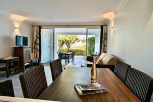 un soggiorno con tavolo e sedie in legno di Les Restanques 3 chambres 3020 a Grimaud