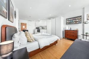 - une chambre avec un grand lit blanc et une table dans l'établissement Stylish Piccadilly 1 BR Flat in London VR2, à Londres