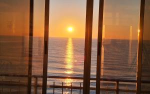 einen Sonnenuntergang durch das Fenster eines Kreuzfahrtschiffes in der Unterkunft Tavernes de Valldigna Chez Svetlana in El Brosquil