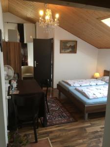 a bedroom with a bed and a table and a chandelier at Pension Zur Freiheit in Passau