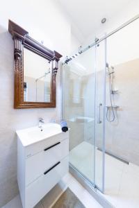 a bathroom with a white sink and a shower at Bohéme Apartments Charle's Square in Prague