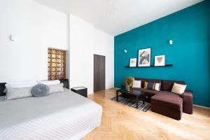 a bedroom with a bed and a couch at Bohéme Apartments Charle's Square in Prague