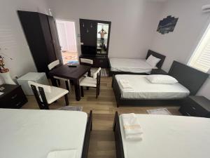um pequeno quarto com duas camas e uma mesa em Bujtina cela em Berat