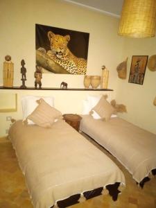 2 Betten in einem Zimmer mit einem Leopardenmuster in der Unterkunft Villa rouge in Marrakesch
