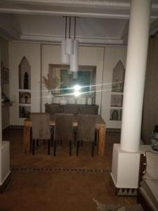 ein Esszimmer mit einem Tisch, Stühlen und einem Spiegel in der Unterkunft Villa rouge in Marrakesch