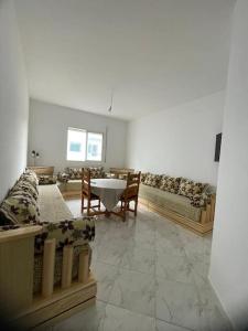 a living room with a couch and a table and chairs at Appartement à louer Al Hoceima - Igar Azougar in Al Hoceïma