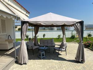 einen Pavillon mit Stühlen und einen Tisch auf der Terrasse in der Unterkunft Bujtina cela in Berat