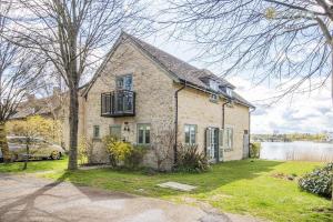 a brick house with a balcony and a lake at Mill Village 68, Somer House - P in Somerford Keynes