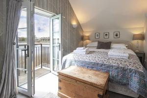 a bedroom with a bed and a balcony at Mill Village 68, Somer House - P in Somerford Keynes +24 photos