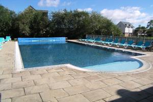 a swimming pool with blue chairs and a bunch ofitures at Mill Village 68, Somer House - P in Somerford Keynes