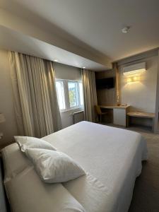 a bedroom with a large white bed with a window at San Luis in Vilaboa