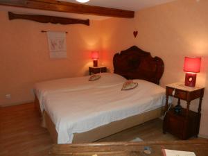 a bedroom with a large white bed with two lamps at Chambres d'hôtes Chez Dany in Gerstheim