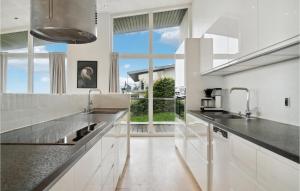 エーベルトフトにあるAwesome Home In Ebeltoft With Wifiのキッチン(白いカウンター、大きな窓付)