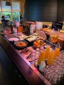 un buffet de comida y bebida en un mostrador en Campanile Caen Est - Mondeville en Mondeville