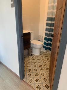 a bathroom with a toilet and a tile floor at Casa Familiar Lago Rapel in Las Balsas +14 photos