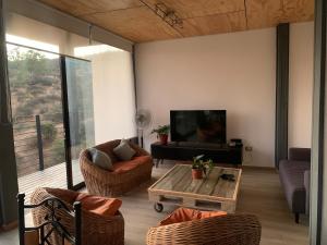 sala de estar con TV, sofá y mesa en Casa Familiar Lago Rapel, en Las Balsas
