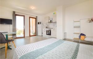 ein weißes Schlafzimmer mit einem Bett und einem Schreibtisch in der Unterkunft Beautiful Apartment In Piana With Kitchen in Piana