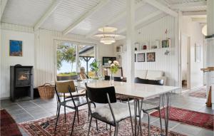 a dining room with a table and chairs and a fireplace at 3 Bedroom Gorgeous Home In Knebel in Knebel