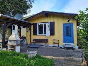 una casa gialla con una porta blu e una panchina di Haus im Gruenen a Weilbach