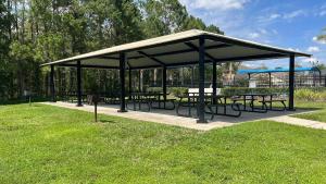 a picnic shelter with tables and benches in a park at Close to Disney. Big house with backyard in Orlando