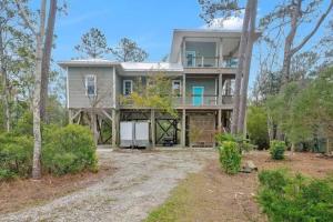 an exterior view of a large house with trees at The TreeHouse by the Sea in Carolina Beach