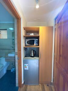 eine kleine Küche mit einer Mikrowelle und einem Kühlschrank in der Unterkunft Hotel Naturaleza Vertientes de Elqui in El Molle