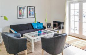 sala de estar con sofá, mesa y sillas en 2 Bedroom Awesome Apartment In Bagenkop, en Bagenkop