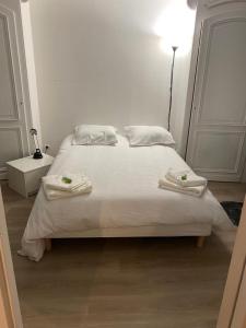 a bedroom with a bed with towels on it at Maison Ancienne à côté des Champs Elysees in Puteaux