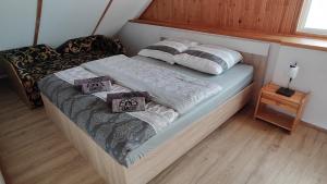 ein Bett mit zwei Kissen auf einem Zimmer in der Unterkunft Ranczo Bieszczady duży Domek z Jacuzzi i Sauną in Mrzygłód