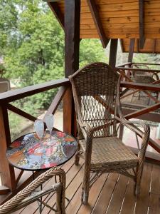 a wicker chair and a table on a porch at La Araucaria VGB in Villa General Belgrano