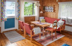 ein Wohnzimmer mit einem Tisch und einem roten Sofa in der Unterkunft Nice Home In Sande I Vestfold With House A Panoramic View in Svelvik