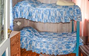 Schlafzimmer mit einem Bett mit blauer und weißer Bettwäsche in der Unterkunft Nice Home In Sande I Vestfold With House A Panoramic View in Svelvik