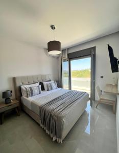 una camera con un grande letto e una grande finestra di Villa Dianthus Zakynthos a Sarakinádhon