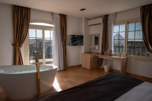 a bathroom with a bath tub and a large window at Palm Pyramids View INN in Cairo