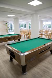two pool tables in a room with tables and chairs at ALEGRIA Fenals Mar in Lloret de Mar