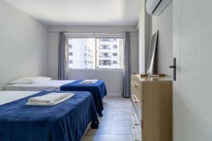 ein Hotelzimmer mit 2 Betten und einem Fenster in der Unterkunft Apto 3min da Praia de Balneário Camboriú ERO301 in Balneário Camboriú