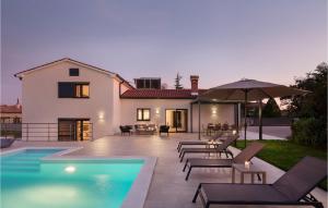 Vinež的住宿－Villa Del Sol，一座房子,设有游泳池、椅子和遮阳伞