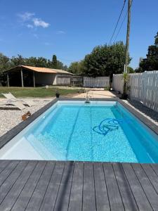 a small swimming pool with a wooden deck at Les Mazets du Paty in Albaron